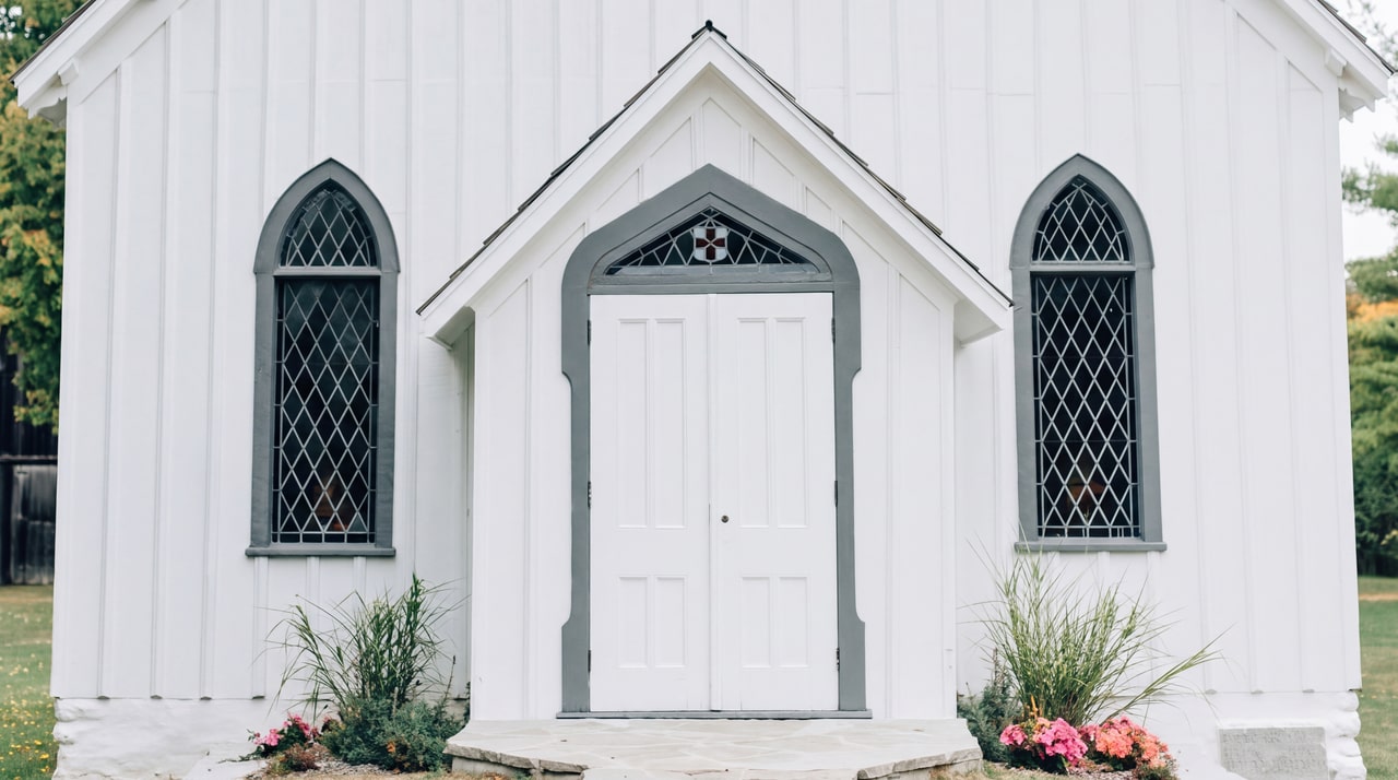 White chapel entrance with Gothic windows and pink garden flowers at Ball’s Falls.