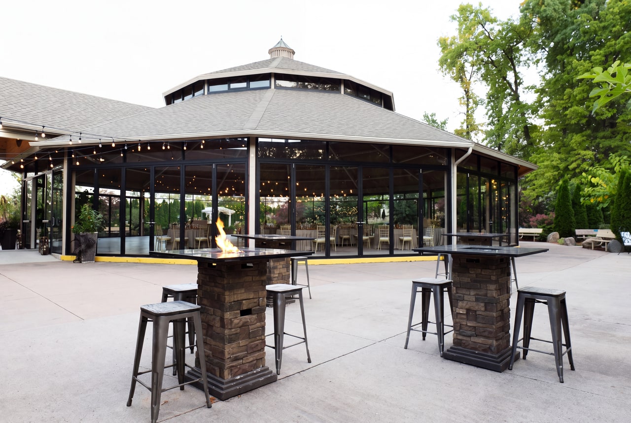 Glazed Garden Pavilion with a low grey roof, small cupola and leafy terrace planting at Club Roma.