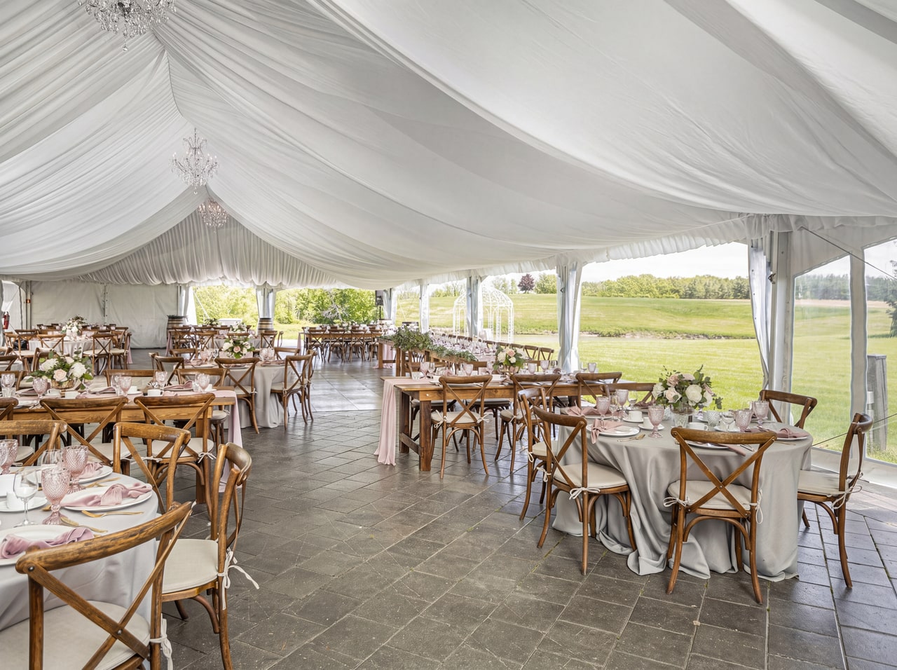 White-draped Moyer Marquee, cross-back chairs and a paved terrace opening onto lawn at Sue-Ann Staff.